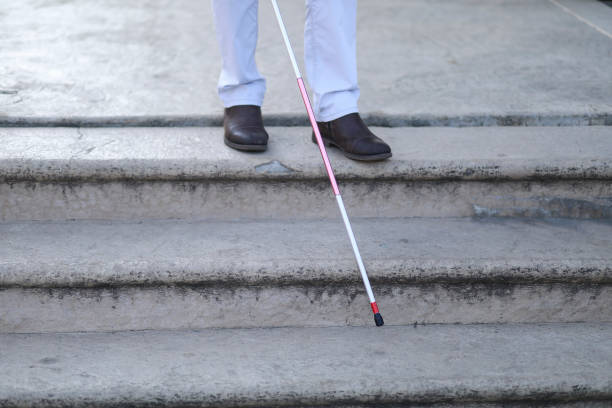 istock Blind and bearded man with a walking stick on the street 1147960157