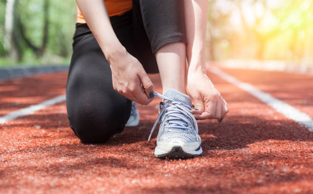 istock Young woman runner tying shoelaces 1147960808