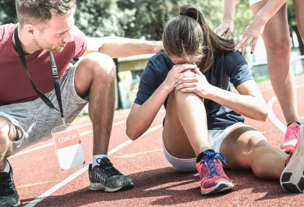 athlète femelle se blessant pendant l’entraînement de course athlétique-entraîneur masculin prenant soin sur l’élève de sport après accident physique-concept de soin d’équipe avec de jeunes gens sportifs faisant face à des accidents de malhe - ménisque photos et images de collection