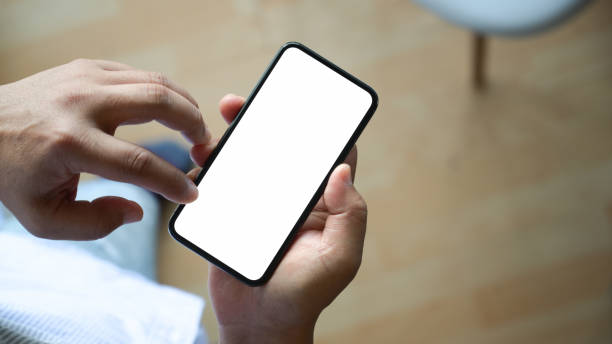 istock Top view man sitting and holding blank screen mock up mobile phone 1147961982