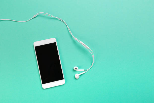istock smartphone with earphones on blue background text place - Image 1147962426