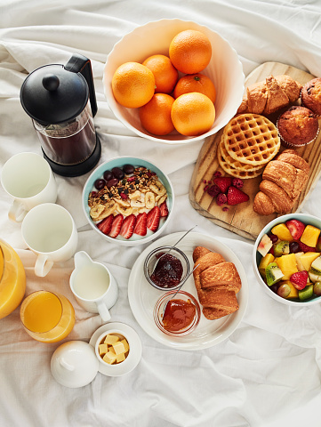High angle shot of a delicious breakfast spread on a bed at home