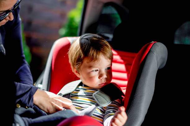 istock Baby boy being fastened in car seat 1147965476