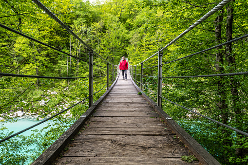 Senior man on a suspension footbridge at River Soca, Julian Alps, Slovenia, Europe