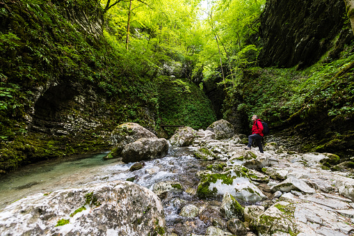 Adventurist exploring the paths of the Amazing Kozjak waterfall in Julian Alps canyon near Kobarid, Slovenia