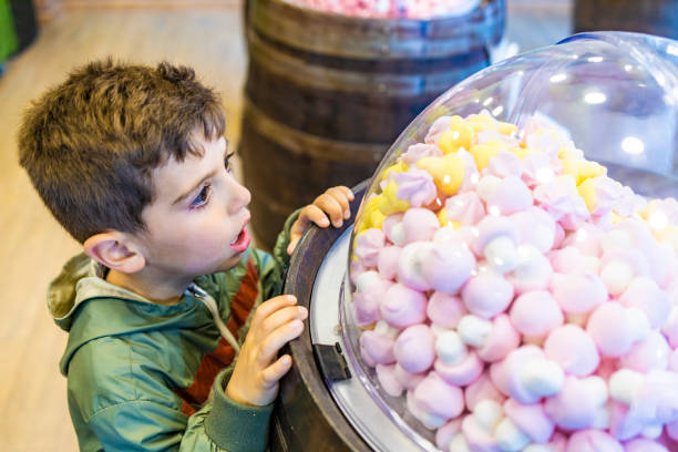 Little kid looking fascinated a candies container Little kid looking fascinated a candies container gawp stock pictures, royalty-free photos & images
