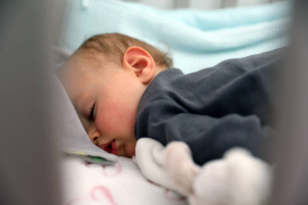 istock Cute Sleeping Baby Boy In Crib 1147970357