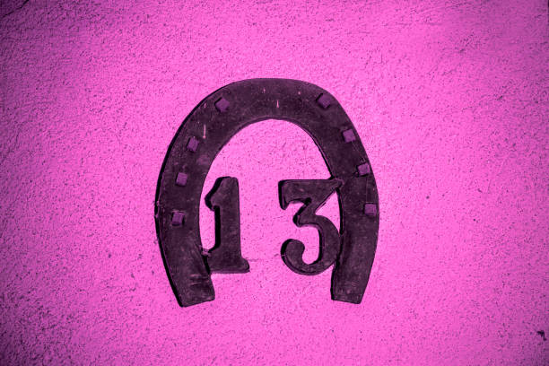Nummer 13 on a pink wall