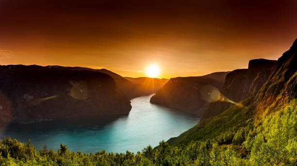 puesta de sol con luz dorada en un fiordo de noruega - sol de medianoche fotografías e imágenes de stock