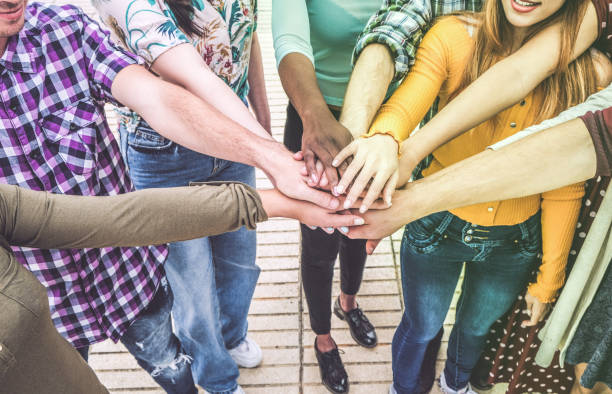 istock Young millennials friends stacking hands together - Happy students celebrating together - Youth lifestyle, university, relationship and friendship concept - Focus on hands 1147974663