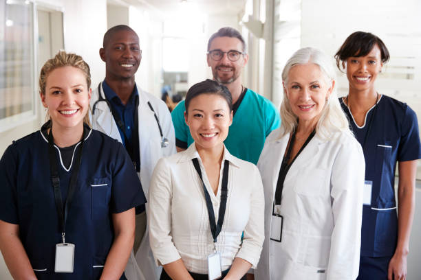 portrait of medical team standing in hospital corridor - medical occupation imagens e fotografias de stock