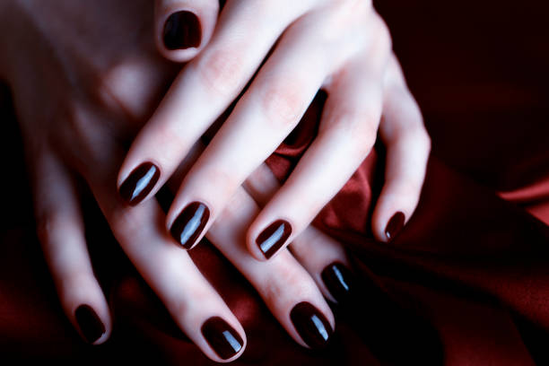 istock Manicure with burgundy nails on burgundy background 1147976775