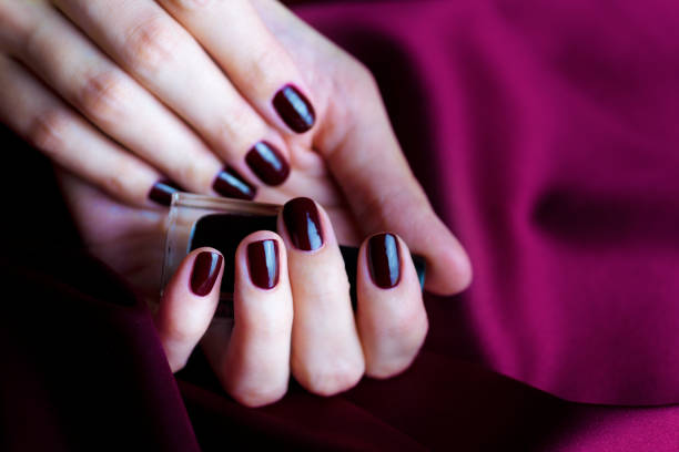 istock Manicure with burgundy nails on burgundy background 1147976791