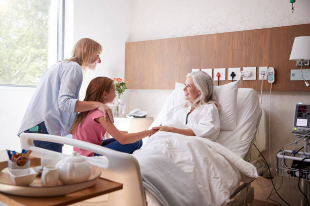 家族病院訪問で祖母と話をしている孫娘 - adult caucasian senior adult family ストックフォトと画像