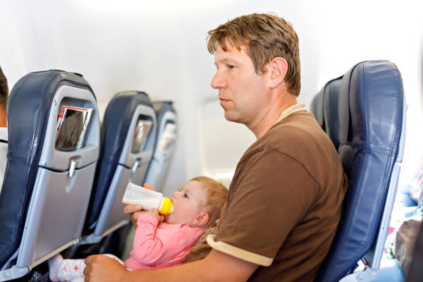 istock Father holding his baby daughter during flight on airplane going on vacations 1147978621