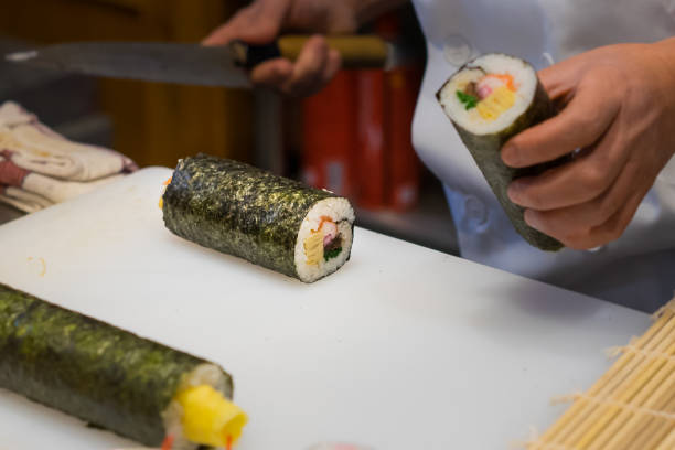 istock Sushi chef prepares maki rolls 1147979485