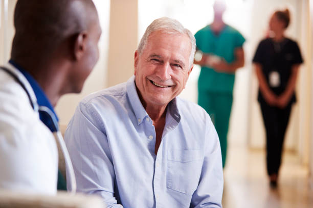 doctor welcoming to senior male patient being admitted to hospital - male nurse black nurse doctor imagens e fotografias de stock