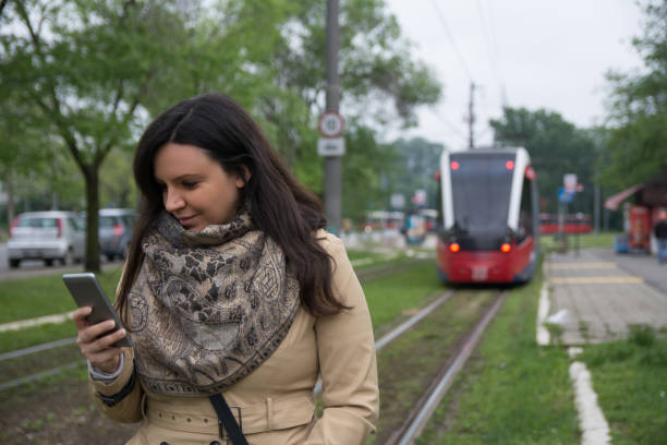 istock Woman using smart phone and waiting for train 1147980975