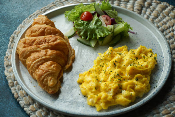 istock Breakfast with croissant, scrambled egg, and vegetables salad 1147982219