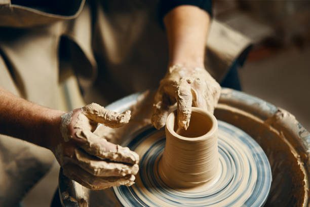 istock Potter modeling ceramic pot from clay on a potter's wheel 1147982232