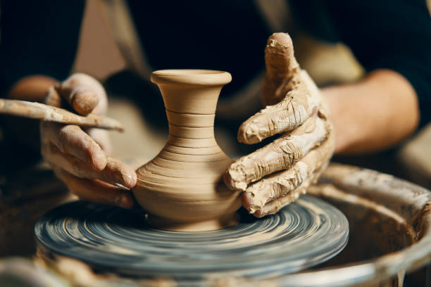 istock Potter modeling ceramic pot from clay on a potter's wheel 1147982236