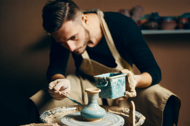 istock Man painting handmade pottery at ceramic workshop 1147982269
