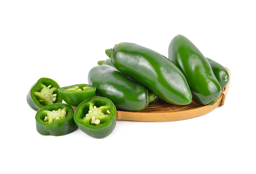 whole and portion cut fresh Jalapeno or Mexican Chili on white background