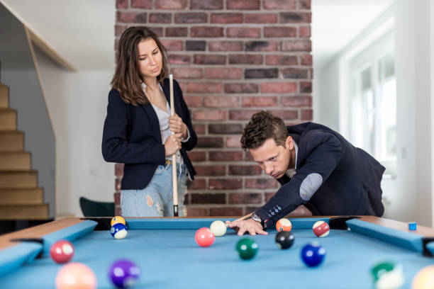 istock Young modern couple in love playing pool table billiard game. 1147985194