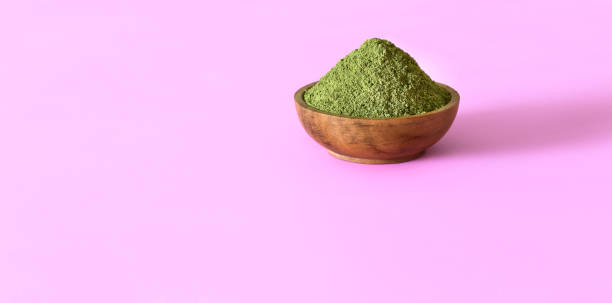 istock Moringa powder (Moringa Oleifera) in wooden bowl on pink background with copyspace. 1147987457