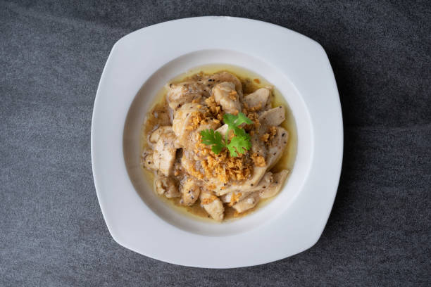 istock Fried chicken with garlic and black pepper in white dish on the concrete table. 1147989586