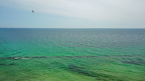 Breakwater in the black sea. View of the horizon. Turquoise clear water. Horizontal background photo with drone