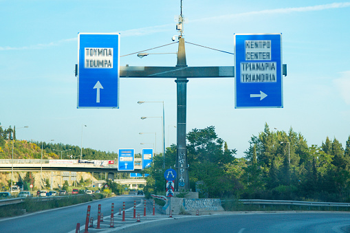 A picture of big blue road  signs,in a street outside a Greek town Thessaloniki