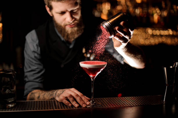 istock Bartender sprinkles an alcohol cocktail in glass 1147995394