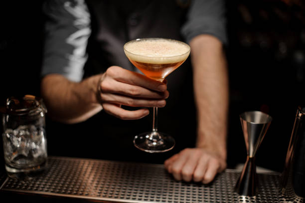 istock Close shot of bartender holding cocktail with foam 1147996044