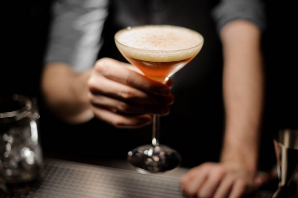 istock Close-up of bartender holding cocktail with foam 1147996281