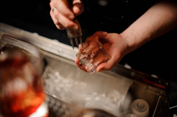 istock Close-up of bartender holding ice and ice crusher 1147996859