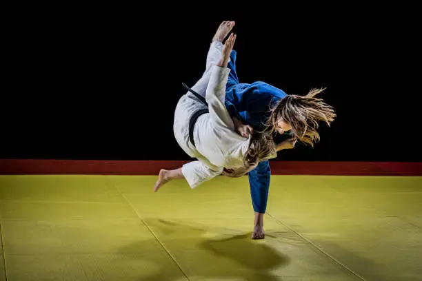 Two female judo players fighting during competition.