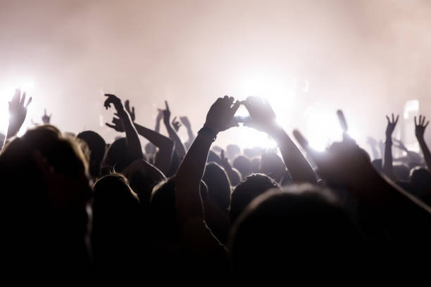 istock Crowd with raised hands and smartphone record a concert. 1147997258