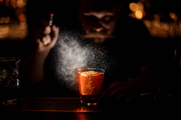 istock Darkened picture of bartender pours an alcohol cocktail using sprayer 1147997476