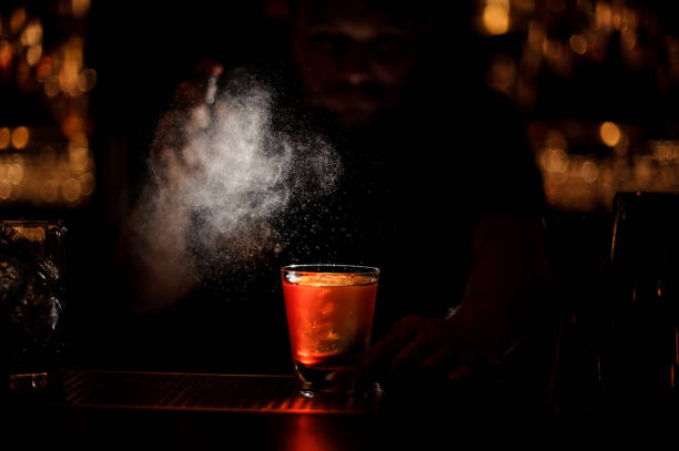 istock Darkened shot of bartender pours an alcohol cocktail using sprayer 1147997504