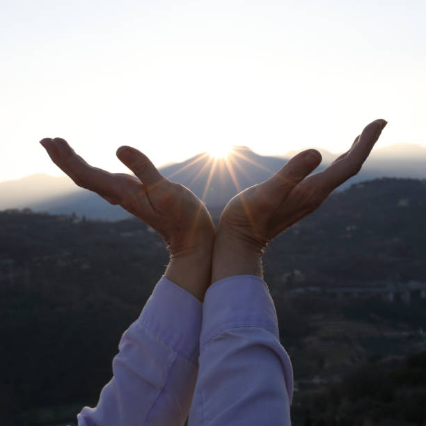 istock Woman raises cupped hands to sky 1147997814
