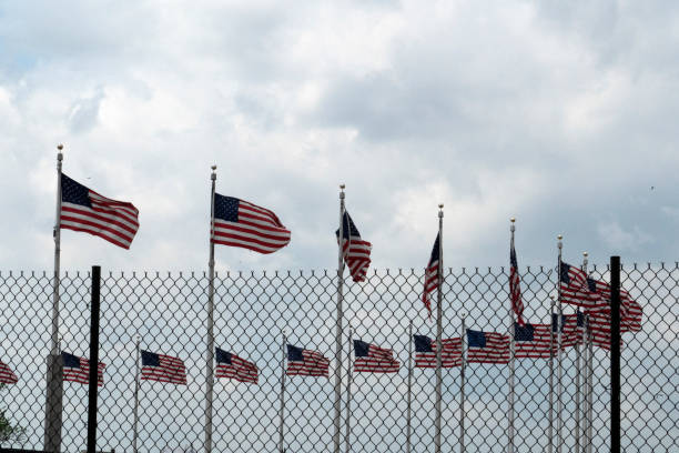 istock Waving usa flags behind fence grid 1147999127