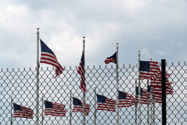 istock Waving usa flags behind fence grid 1147999164
