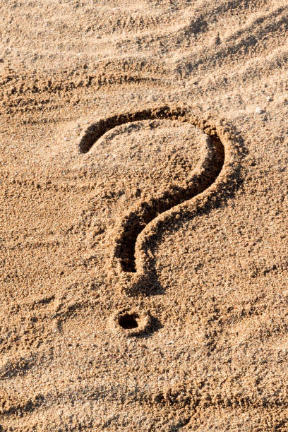 istock question marks written on beach sand close up, with copy space 1148000480