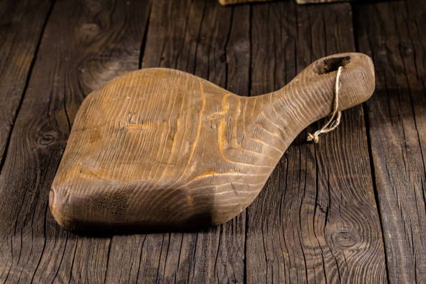 istock Russia, rustic old vintage wooden cutting board for the kitchen, with a groove structure, stripes, lies, stands on the table are cracks, black, brown, round square oval right angles sharp, rope 1148002997