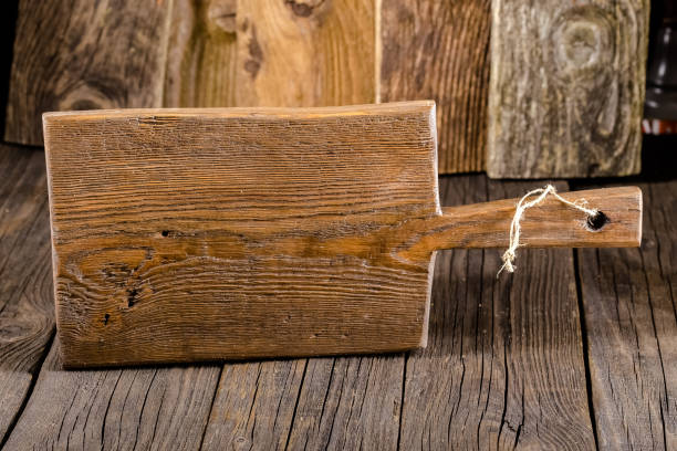 istock Russia, rustic old vintage wooden cutting board for the kitchen, with a groove structure, stripes, lies, stands on the table are cracks, black, brown, round square oval right angles sharp, rope 1148003050