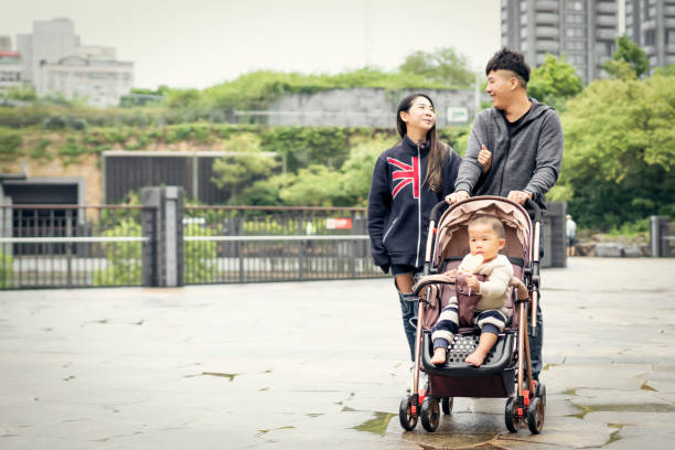 istock Couple Push Son Walk In The Park 1148003194