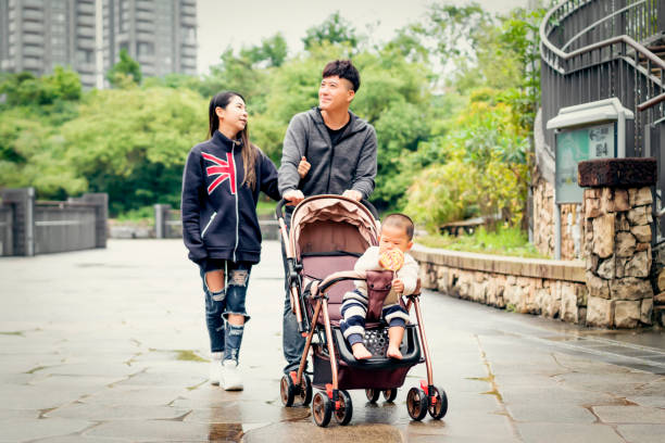 istock Couple Push Son Walk In The Park 1148003206