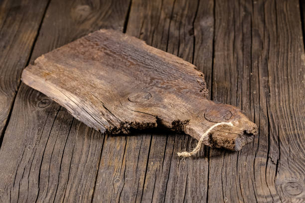 istock Russia, rustic old vintage wooden cutting board for the kitchen, with a groove structure, stripes, lies, stands on the table are cracks, black, brown, round square oval right angles sharp, rope 1148003229