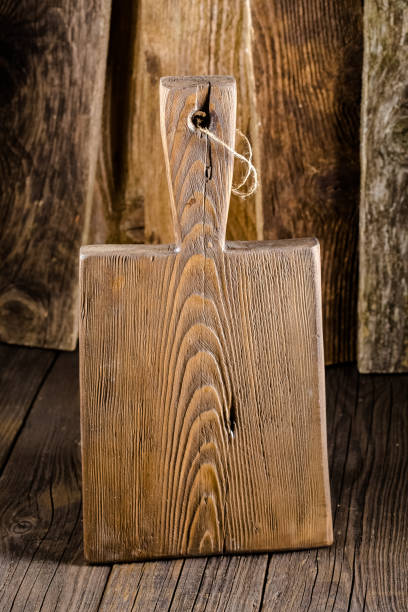 istock Russia, rustic old vintage wooden cutting board for the kitchen, with a groove structure, stripes, lies, stands on the table are cracks, black, brown, round square oval right angles sharp, rope 1148003275